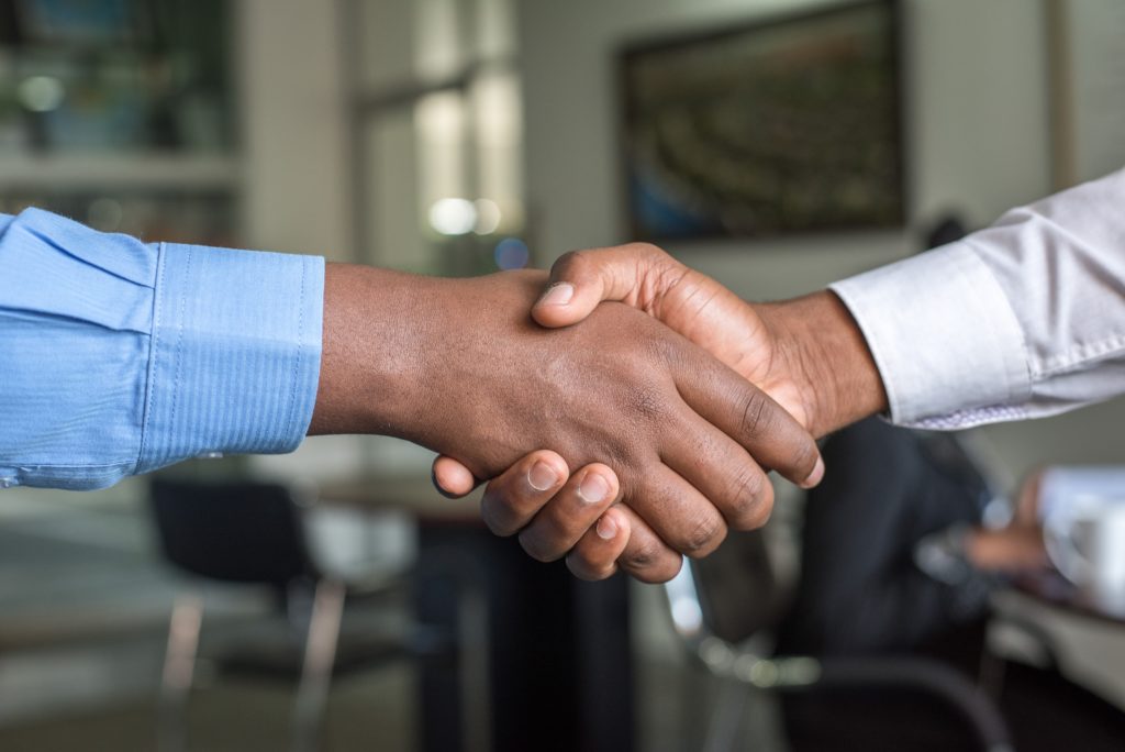 Sales medewerker handen schudden